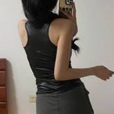 Person wearing a black sleeveless top and gray pants taking a mirror selfie.